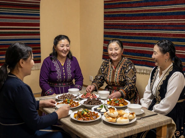 Kyrgyz family sharing traditional beshbarmak meal together demonstrating warm hospitality and generational family bonds