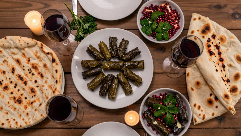 Beautifully arranged Armenian dinner table with dolma lavash kebabs and pomegranate salad for romantic date night